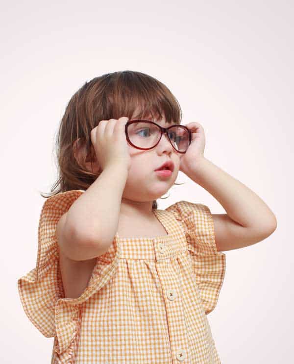 a girl wearing glasses with pink background