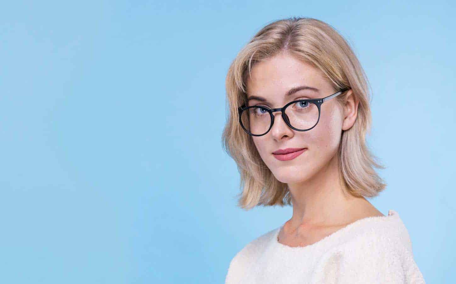 a woman with glasses on isolated blue background